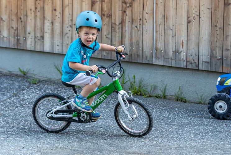 Kinder spielen mit Tretfahrzeugen im Bauernhofurlaub