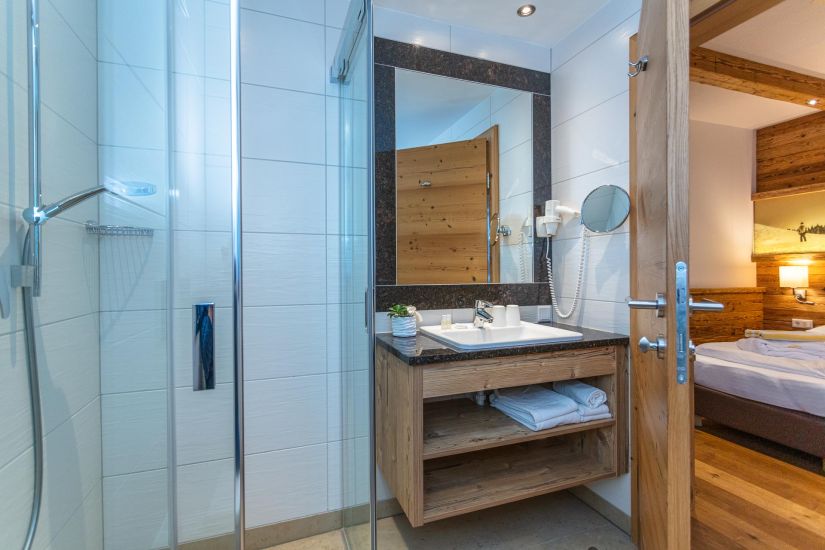 Badezimmer mit Dusche, Waschbecken und Spiegel