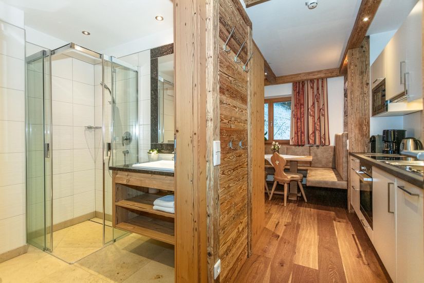 Badezimmer mit Dusche und Waschbecken neben der Küchenzeile