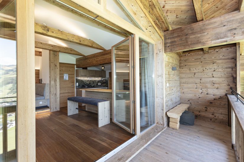 Balkon der Ferienwohnung 80 mit großer Glasfront, Zugang zum Balkon und Blick in die Wohnküche