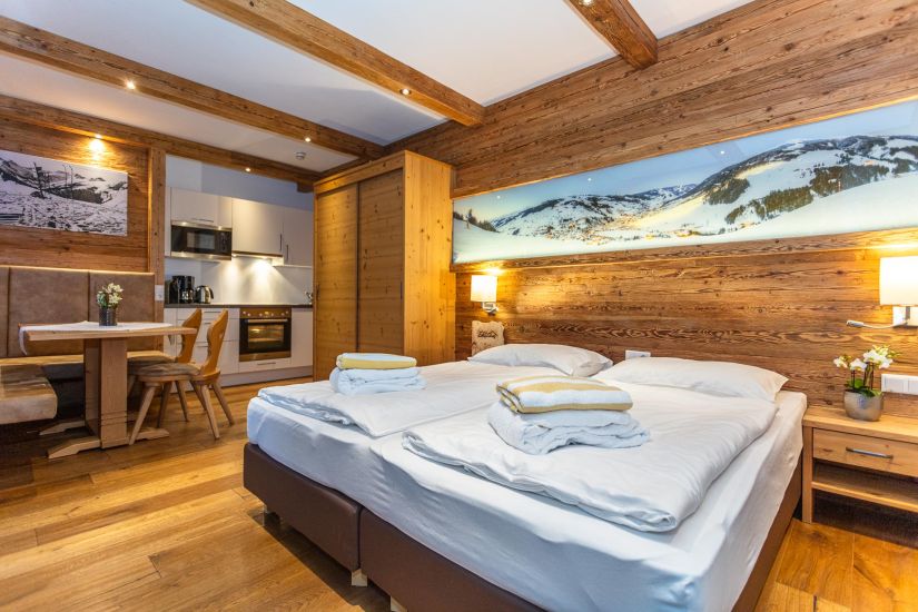 Schlafbereich mit Doppelbett, Essecke und Küchenzeile