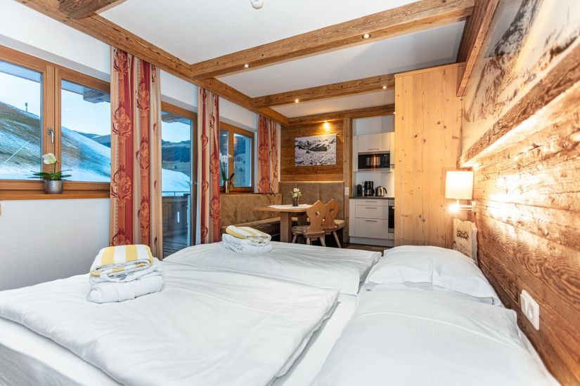Wohn-Schlafraum mit Doppelbett, Essecke und Küchenzeile
