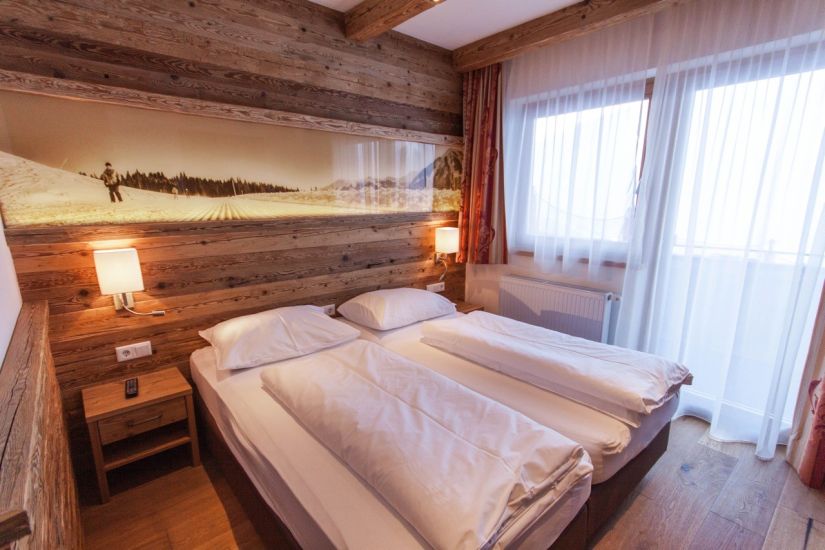 Schlafzimmer mit Doppelbett und großem Fenster
