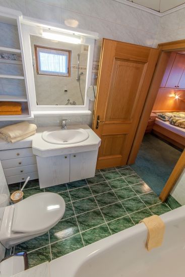 Badezimmer des Doppelzimmers 91 im Bauernhaus mit Badewanne, WC und Waschbecken