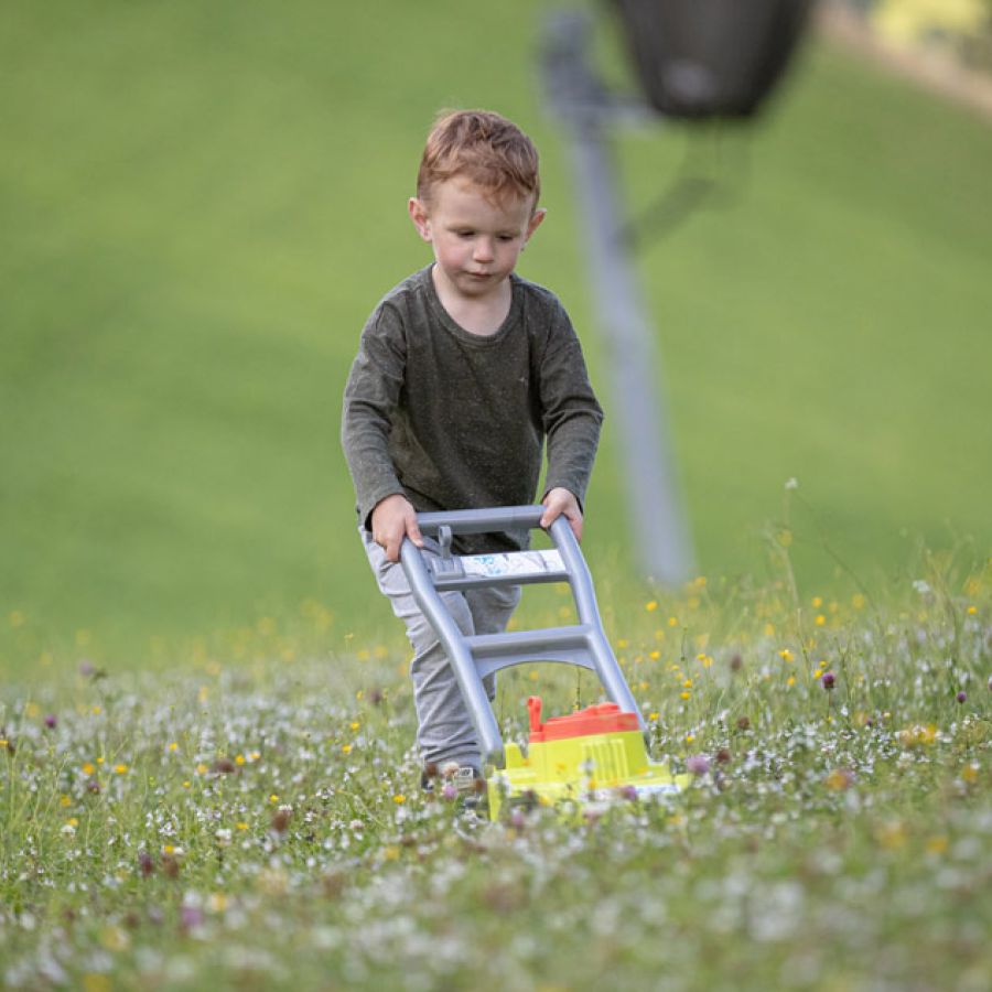 Kind mit Spielzeug Rasenmäher