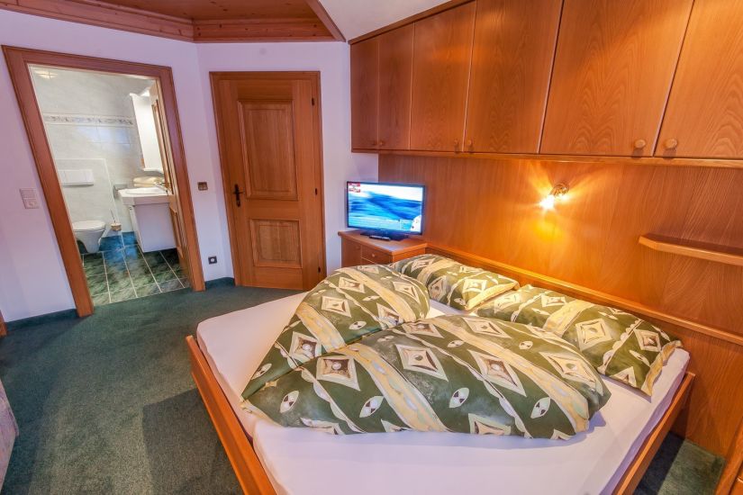 Doppelzimmer 91 im Bauernhaus in Saalbach Hinterglemm mit Doppelbett, Sitzecke und Flat-TV