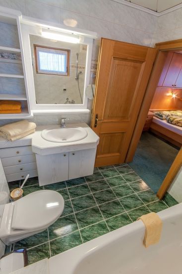 Badezimmer des Doppelzimmers 91 im Bauernhaus mit Badewanne, WC und Waschbecken