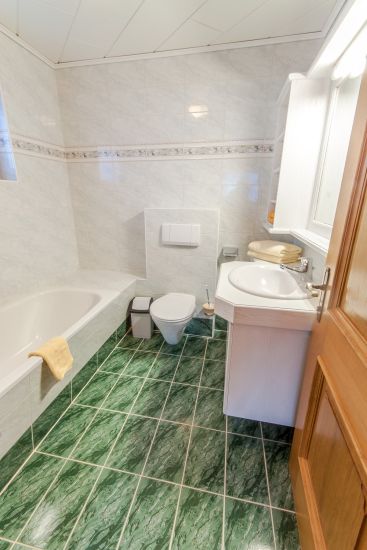 Badezimmer des Doppelzimmers 91 im Bauernhaus mit Badewanne, WC und Waschbecken