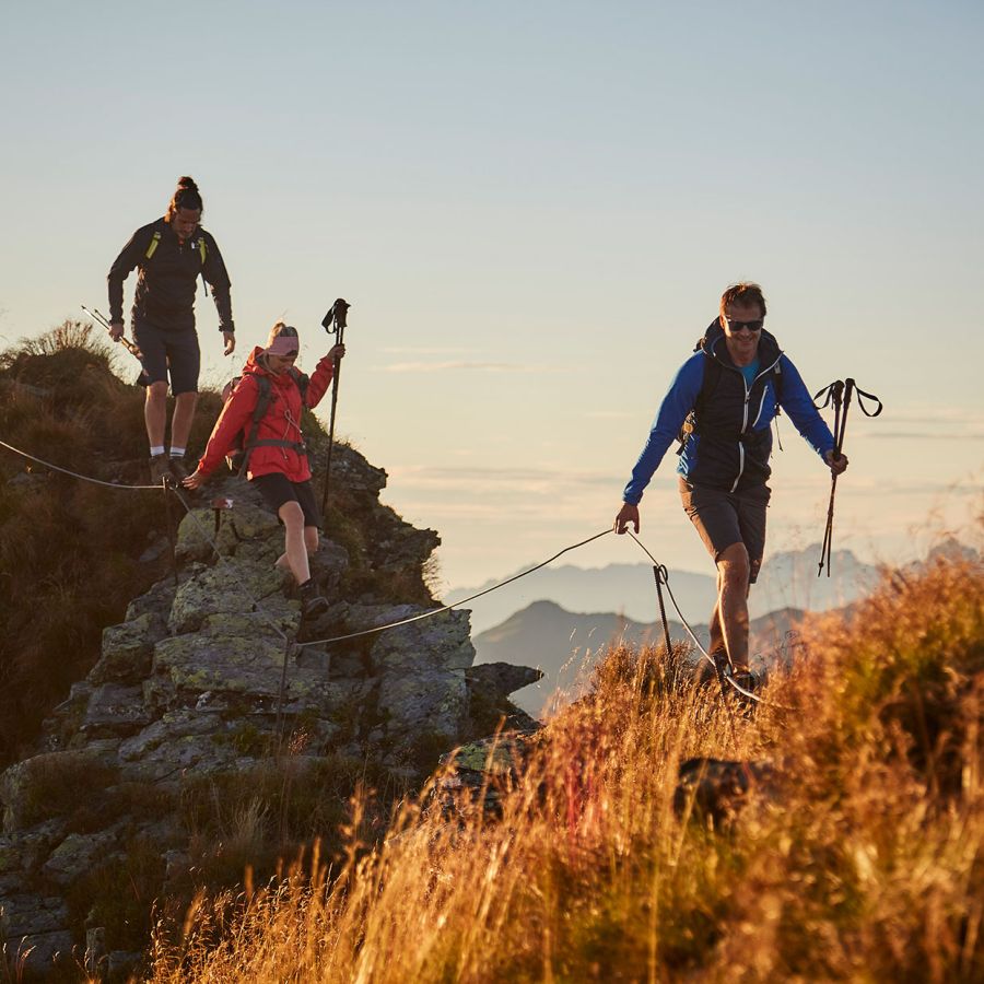 Bergwanderer überqueren einen felsigen Grad in den Hinterglemmer Grasbergen